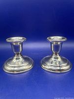 Pair of silver-plated candlesticks side by side showing overall form and finish