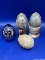 Group shot of four eggs and two stone stands