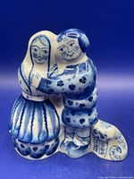Front view of blue and white Gzhel porcelain figurine showing embracing couple