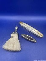 Crumb brush, nail buffer, and tray displayed together