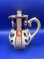 Right side view showing full shape, handle, lid and painted decoration