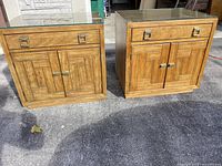Both Drexel Woodbriar cabinets side by side showing fronts, hardware, and glass tops