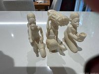 Front view of three figures showing overall form and details