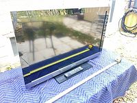 Front view of Sony TV on stand with measuring tape indicating width