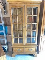 Full front view of cabinet closed showing glass doors and drawers