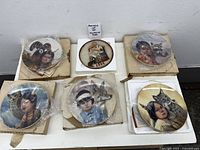 Six boxed plates laid out on table