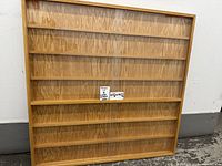 Front view of square wooden display rack with shelves and acrylic front