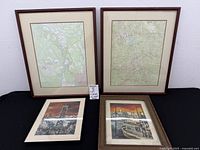 Overall view showing two large framed maps and two smaller framed prints