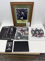 Full lot view showing framed signed photo, stack of programs, season guide, photo print, disc case