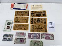 All items laid out showing six brown Confederate replicas, British Armed Forces notes, fractional currency replicas, envelope and card