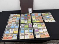 Binder and seven sheets of Pokémon cards laid out showing full lot