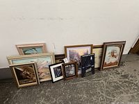 All nine framed artworks lined against wall