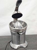 Front view of Breville stainless steel citrus press juicer with lever arm raised