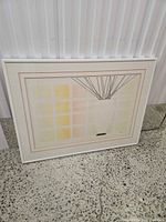 Front view of framed print leaning against wall