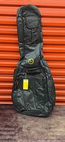 Full view of black RockBag acoustic guitar gig bag against red background