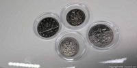 Group shot of four Canadian coins in protective capsules