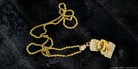 Full view of gold-tone rope chain and Bart Simpson CZ pendant against black background