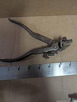 Full view of saw set pliers next to ruler for scale