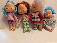 Front view of four Strawberry Shortcake dolls showing outfits and hair
