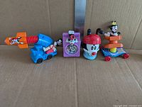 Four assorted Animaniacs toys including Dot rocket car, Yakko viewer block, Wakko bobble-head and Dot skateboard