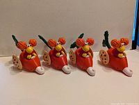 Four orange radish cars with red-haired Fraggle figures