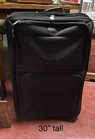 Front view of black soft-sided suitcase showing overall design and size reference text