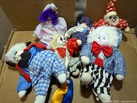 All seven porcelain-headed clown dolls laid on box