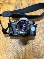 Front view of Pentax Program Plus camera with 50 mm lens and strap