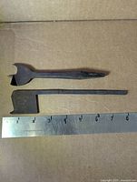 Top: spade drill bit; bottom: dado plane iron with ruler for scale