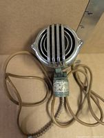 Front view showing chrome grille and attached cable