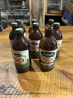 Eight Labatt 50 brown glass stubby beer bottles arranged on wooden surface