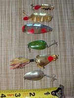 All six Lucky Strike lures aligned beside ruler for scale