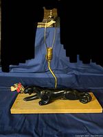 Overall view of McCoy black panther lamp on wood base showing brass socket, harp and cord