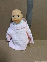 Front view of 8" Rafflor Babyville doll wearing pink knitted sweater
