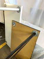 Underside of both tables showing detachable metal legs and mounting plates