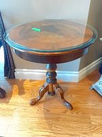Full view of burr walnut round table with glass top and tripod base