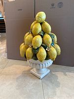 Full view of ceramic lemon topiary on urn