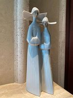 Full view of figurine showing two female figures in pleated gowns