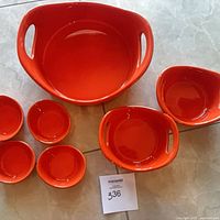 All seven orange ceramic pieces arranged on floor