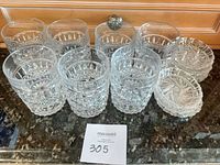 Front view of 7 cut glass tumblers and stacked coasters