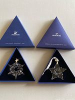 Both Swarovski ornaments in open boxes with lids
