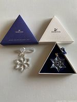 Both ornaments with their triangular boxes displayed