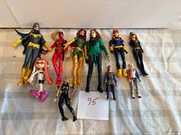 Group shot of all action figures laid out on cloth backdrop with paper label 95