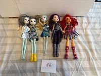 Five Monster High dolls laid out side by side