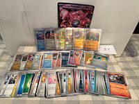 Full lot view showing jumbo Mewtwo ex card, sleeved holos, and stack of assorted standard cards