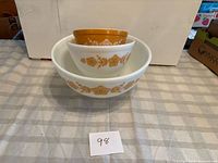 Three nested Pyrex Butterfly Gold bowls, lot number visible