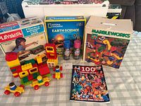 Group shot showing boxed Lincoln Logs, Earth Science Kit, Marbleworks, two Puff containers and LEGO Duplo builds