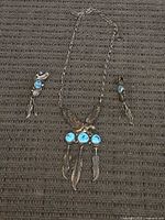 Full view of necklace and both earrings arranged flat