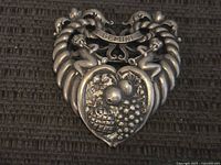 Front view of sterling Gemini brooch showing twin figures, banner, cornucopia sides and fruit cluster