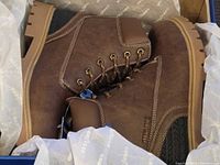 Pair of brown Goodyear steel toe boots inside original box with tissue and tags visible